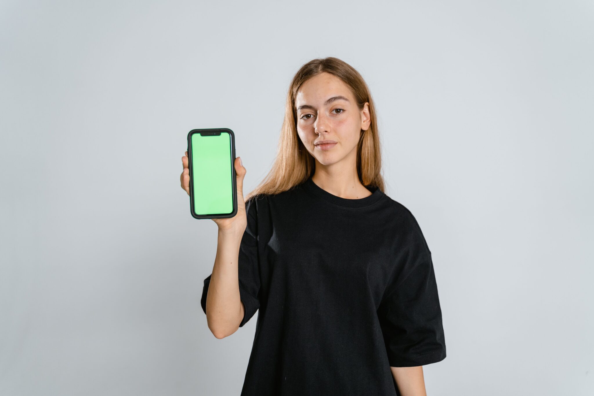 дівчина демонструє зелений екран смартфона